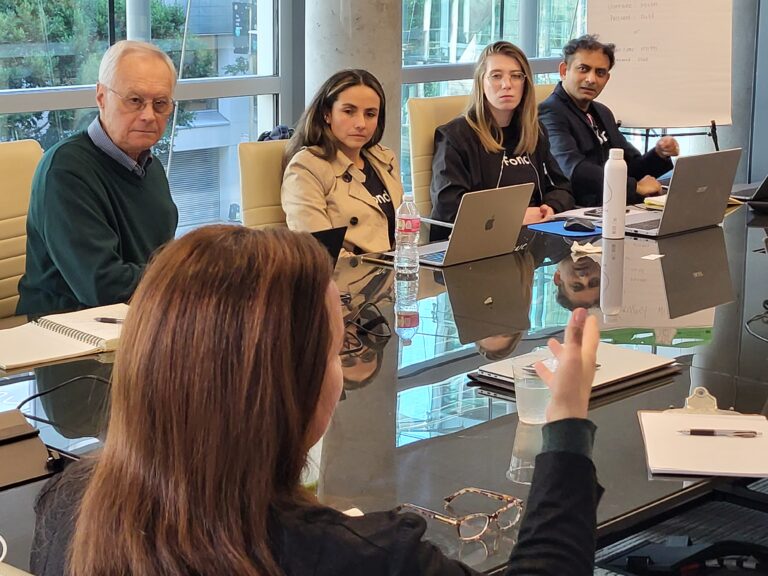 Opus Faveo team and partners collaborating in a strategy meeting around a conference table.